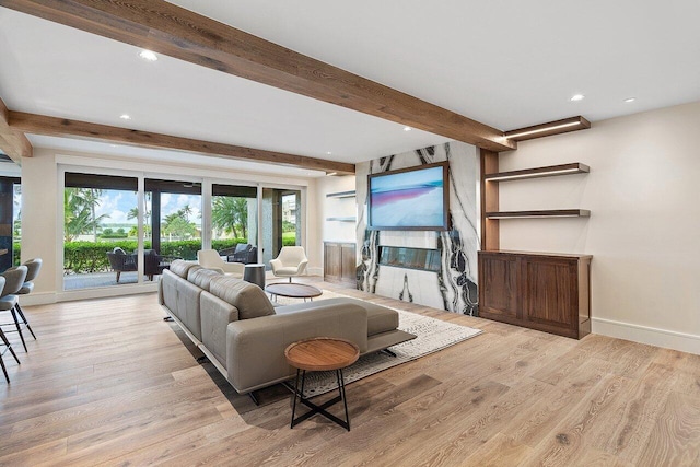 living room featuring beamed ceiling and light hardwood / wood-style flooring