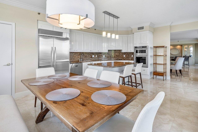 dining room featuring sink and ornamental molding