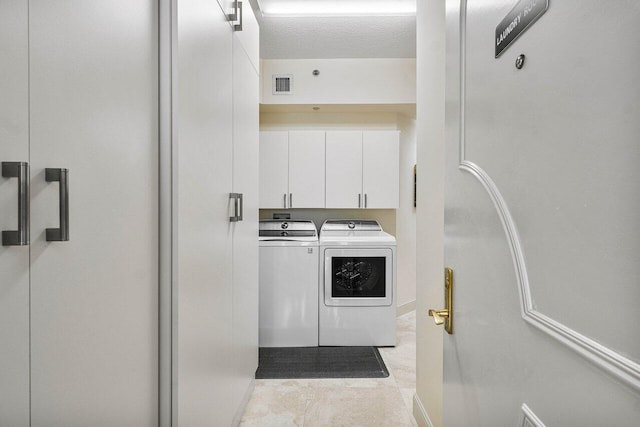 interior space with independent washer and dryer, white cabinets, and light tile patterned floors