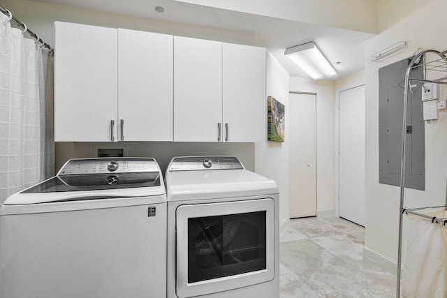 clothes washing area with electric panel, washing machine and dryer, and cabinets