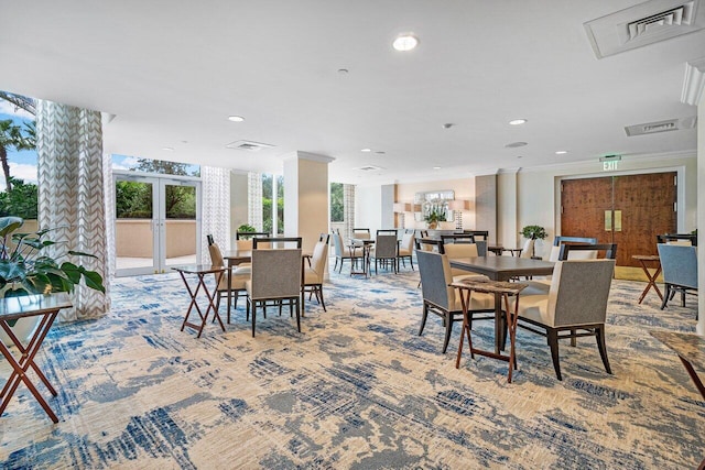 carpeted dining room with ornamental molding and french doors