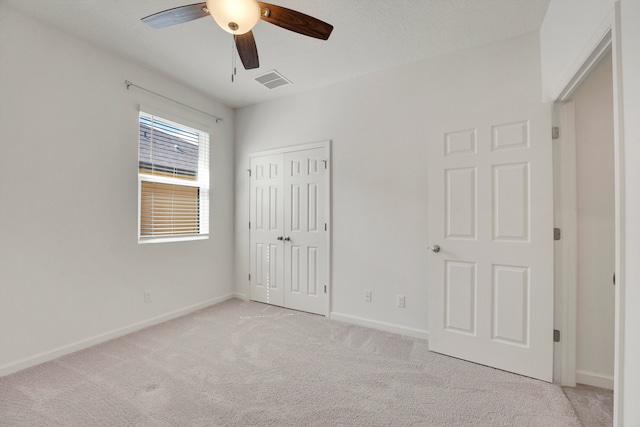 unfurnished bedroom featuring a closet, ceiling fan, and light colored carpet