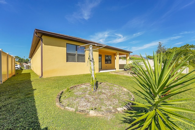 rear view of property featuring a yard and a patio area