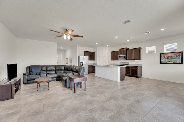 living room with a textured ceiling and ceiling fan