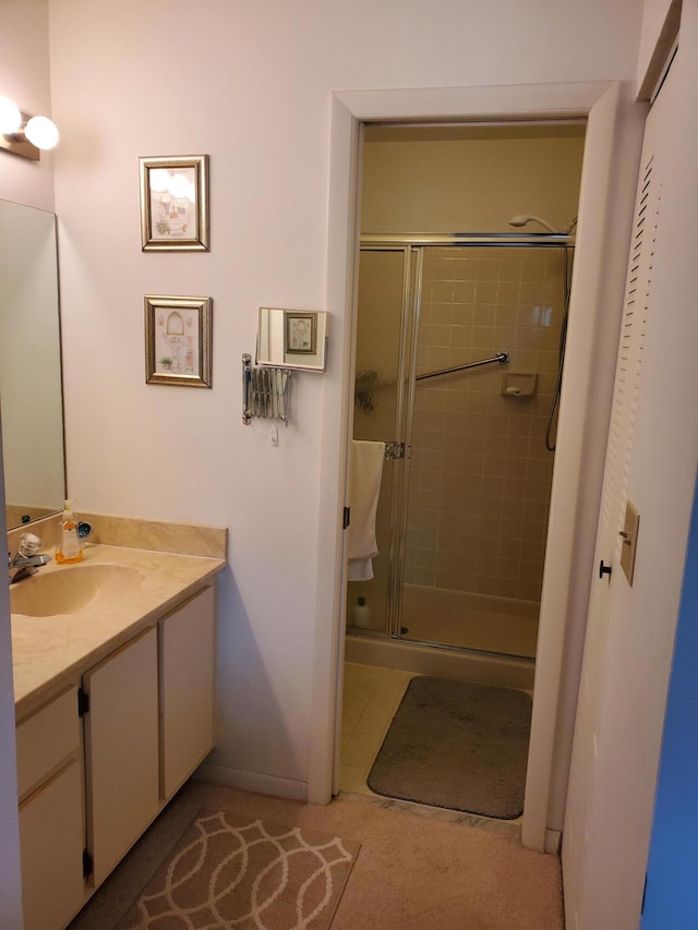 bathroom with tile patterned flooring, an enclosed shower, and vanity