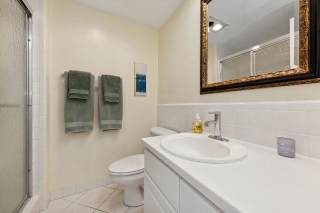 bathroom with a shower with door, vanity, toilet, and tile patterned flooring