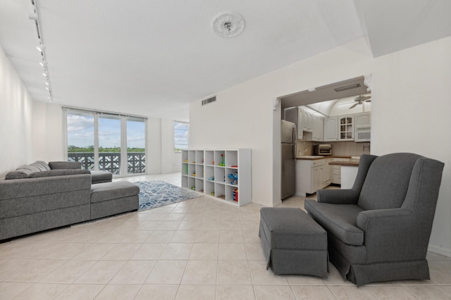 living room with light tile patterned floors, rail lighting, and ceiling fan