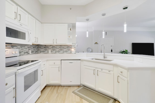 kitchen featuring hanging light fixtures, ornamental molding, sink, white appliances, and white cabinetry