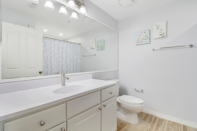 bathroom with hardwood / wood-style flooring, vanity, and toilet