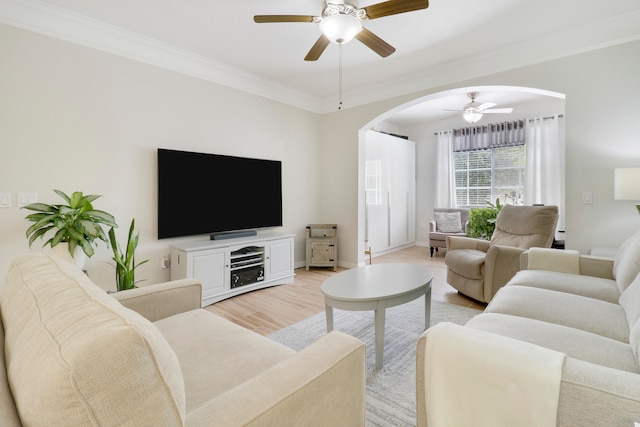 living room with ornamental molding, light hardwood / wood-style floors, and ceiling fan