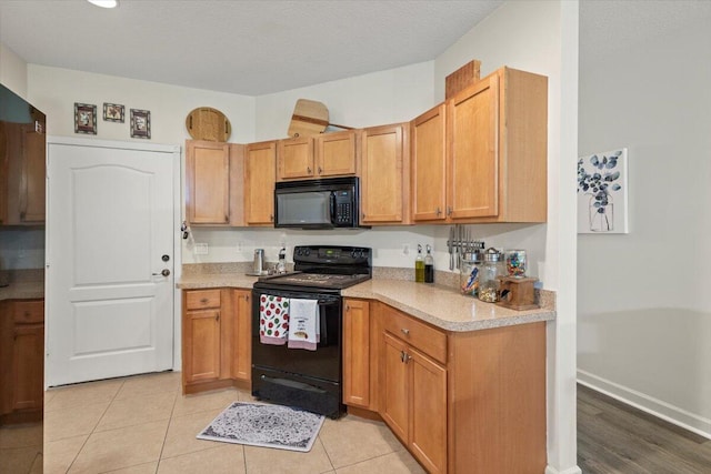 kitchen featuring black appliances, a textured ceiling, and light tile patterned flooring