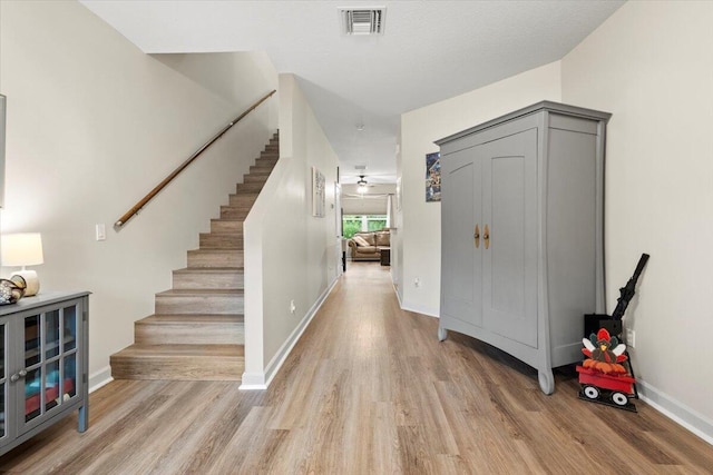 entryway featuring light hardwood / wood-style floors, ceiling fan, and a textured ceiling