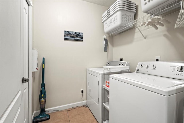 clothes washing area featuring light tile patterned flooring and washing machine and clothes dryer