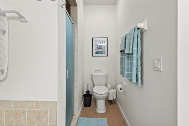 bathroom with toilet, a shower with door, and tile patterned floors