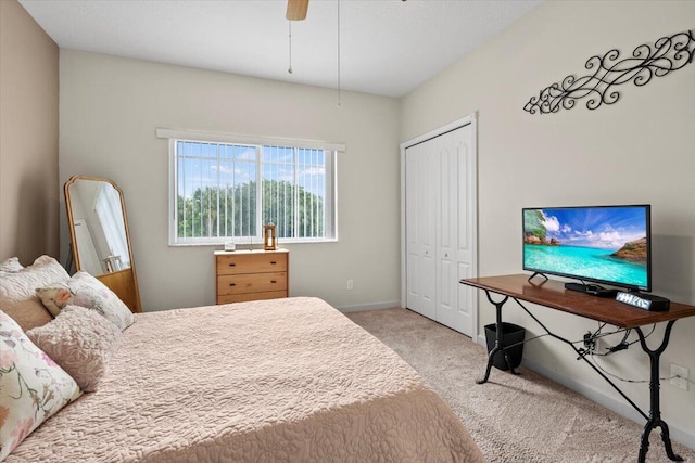 bedroom featuring ceiling fan, light carpet, and a closet