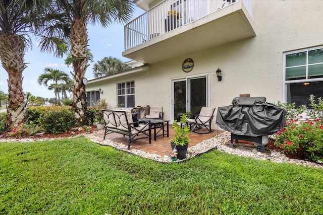 back of house with a balcony, a lawn, and a patio