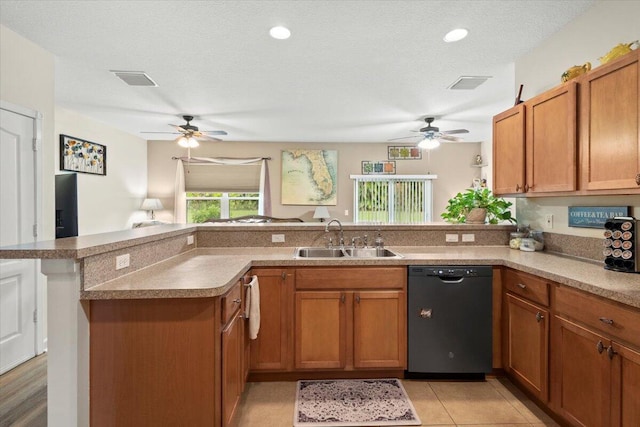 kitchen featuring dishwasher, a textured ceiling, sink, kitchen peninsula, and ceiling fan