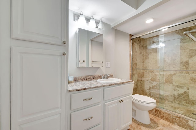 bathroom with toilet, vanity, and walk in shower