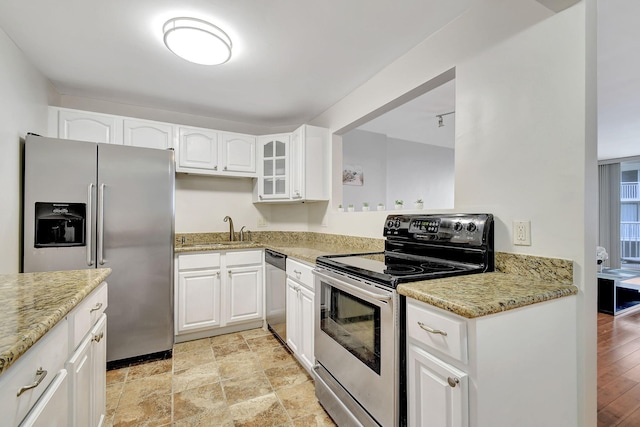 kitchen with white cabinets, sink, light stone counters, and stainless steel appliances