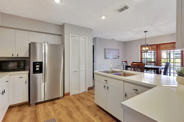 kitchen featuring pendant lighting, an inviting chandelier, white cabinets, sink, and stainless steel fridge with ice dispenser