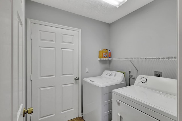 laundry room featuring washing machine and dryer and a textured ceiling