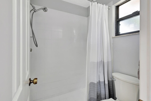 bathroom with a shower with curtain and toilet