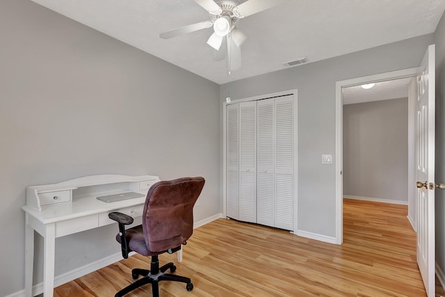 office with light hardwood / wood-style floors and ceiling fan