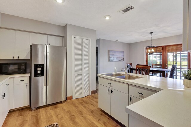 living room with ceiling fan, a towering ceiling, and light hardwood / wood-style floors