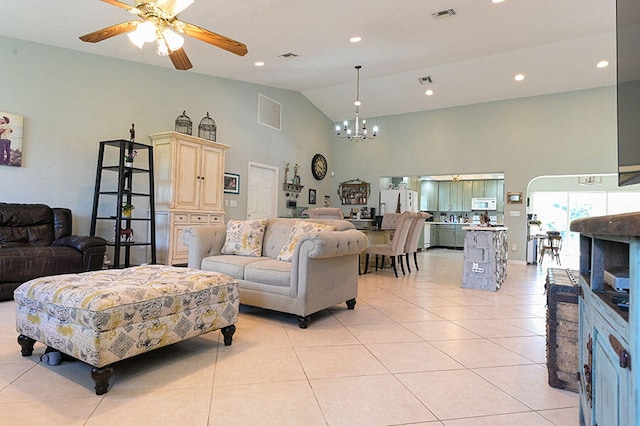 tiled living room featuring ceiling fan with notable chandelier and high vaulted ceiling