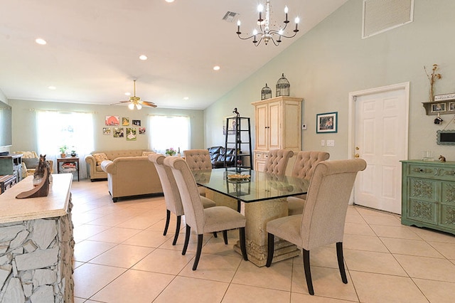 dining room with ceiling fan with notable chandelier, high vaulted ceiling, plenty of natural light, and light tile patterned floors