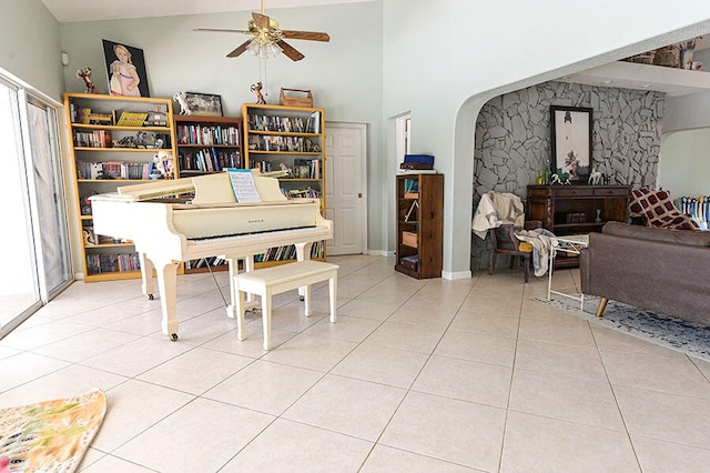 miscellaneous room featuring light tile patterned flooring, high vaulted ceiling, and ceiling fan