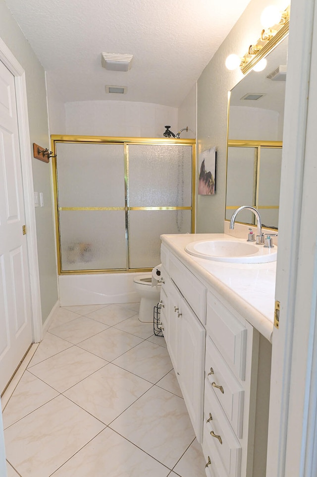 full bathroom with toilet, bath / shower combo with glass door, vanity, and a textured ceiling