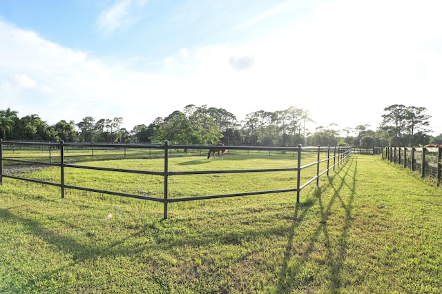 view of gate with a rural view and a yard