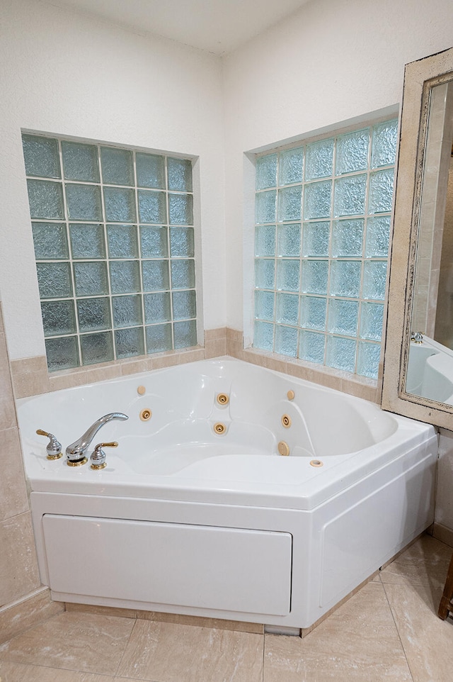 bathroom with tile patterned flooring and a tub to relax in