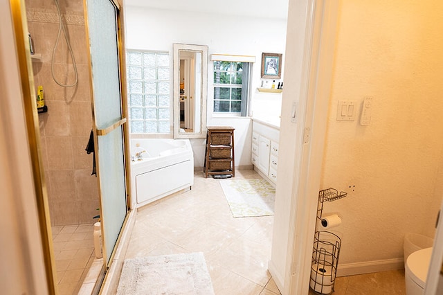 bathroom featuring tile patterned flooring, shower with separate bathtub, and toilet