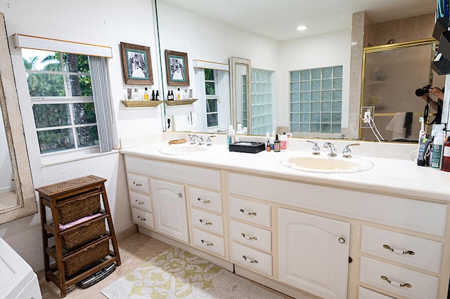 bathroom with tile patterned flooring, a shower with shower door, and vanity