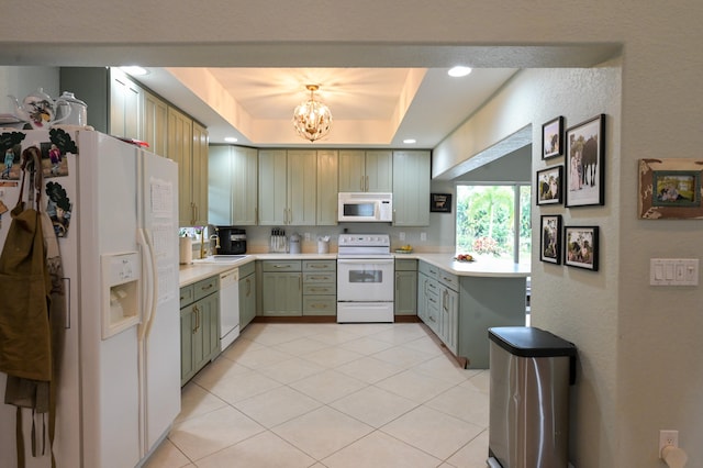 kitchen with white appliances, a tray ceiling, green cabinetry, sink, and light tile patterned floors