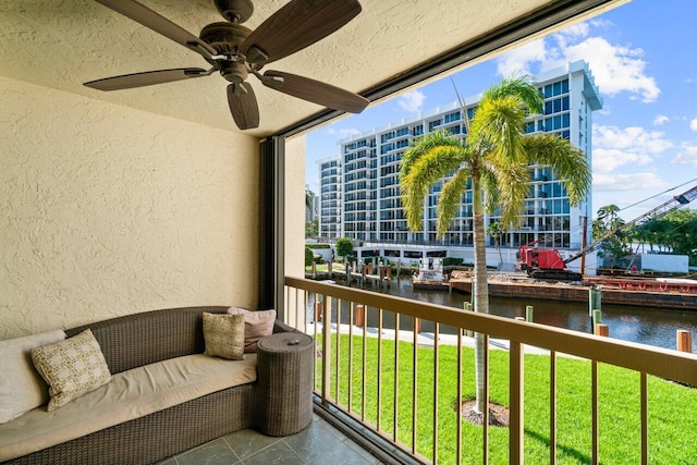 balcony with a water view and ceiling fan