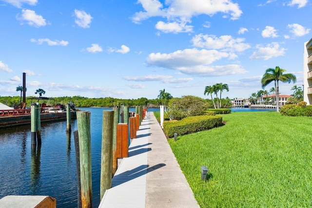 view of dock with a water view and a lawn