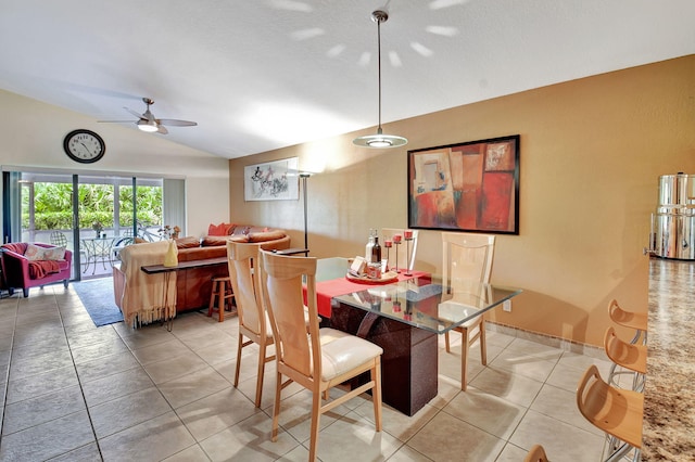 tiled dining room with ceiling fan and lofted ceiling