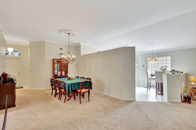 carpeted dining room featuring ornamental molding, a textured ceiling, and a notable chandelier