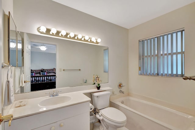 bathroom featuring a washtub, vanity, toilet, and ceiling fan