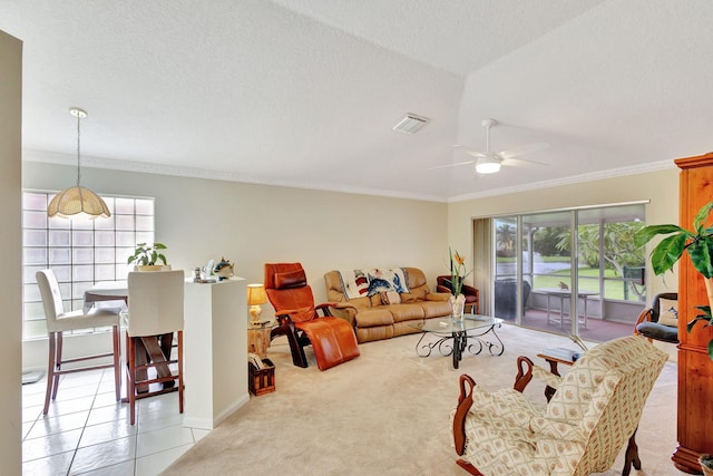 living area featuring a textured ceiling, a ceiling fan, visible vents, light carpet, and crown molding