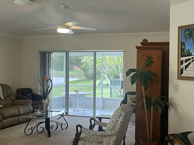 carpeted living room featuring ceiling fan and crown molding