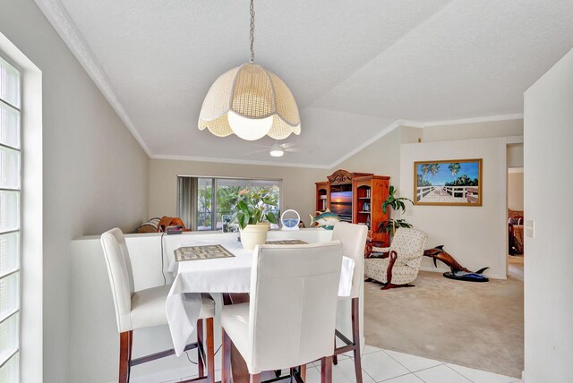 kitchen with dishwasher, light tile patterned floors, decorative light fixtures, and lofted ceiling