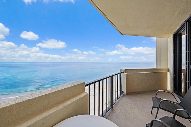 balcony featuring a water view and a beach view