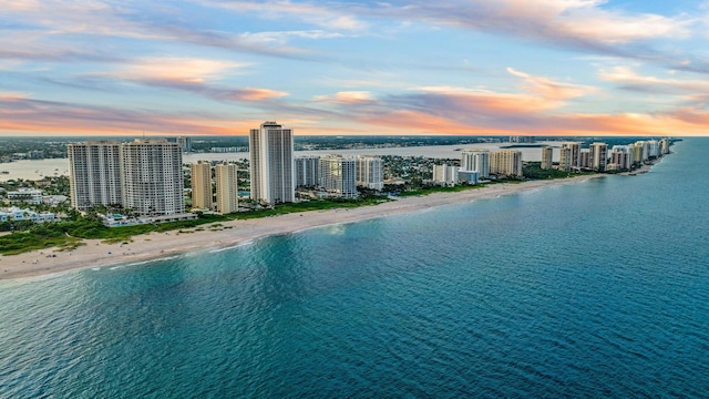 aerial view at dusk with a beach view and a water view