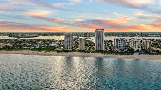 aerial view at dusk with a view of the beach and a water view