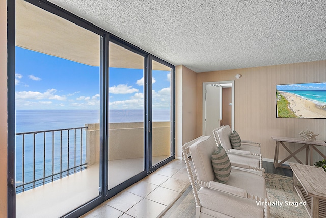 tiled living room with a water view and a textured ceiling