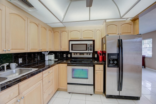 kitchen featuring light brown cabinetry, appliances with stainless steel finishes, and light tile patterned flooring